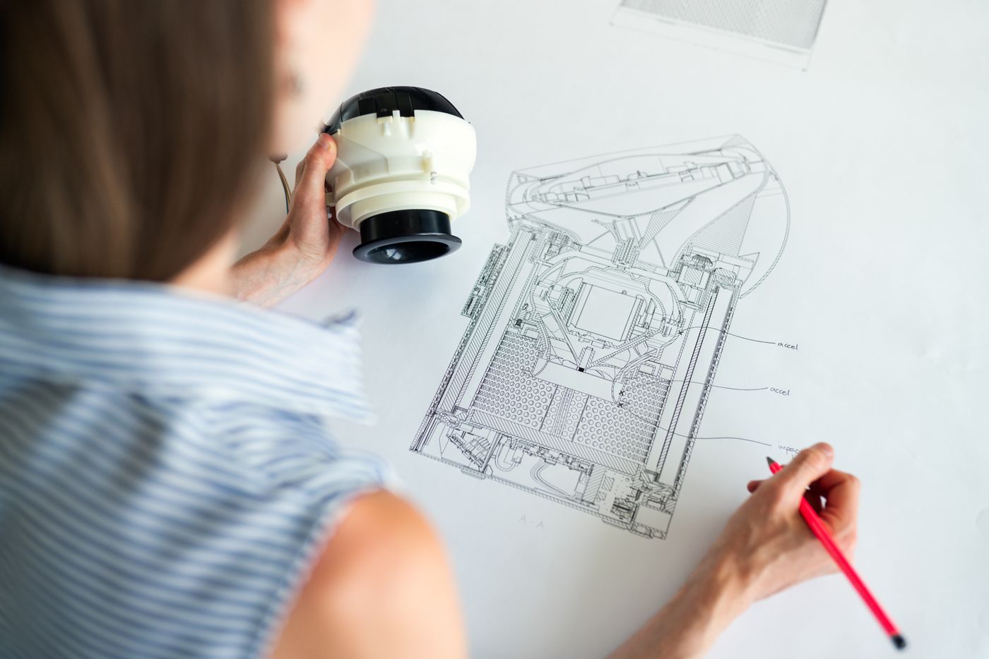 An engineer comparing a component with an equipment cross-section drawing