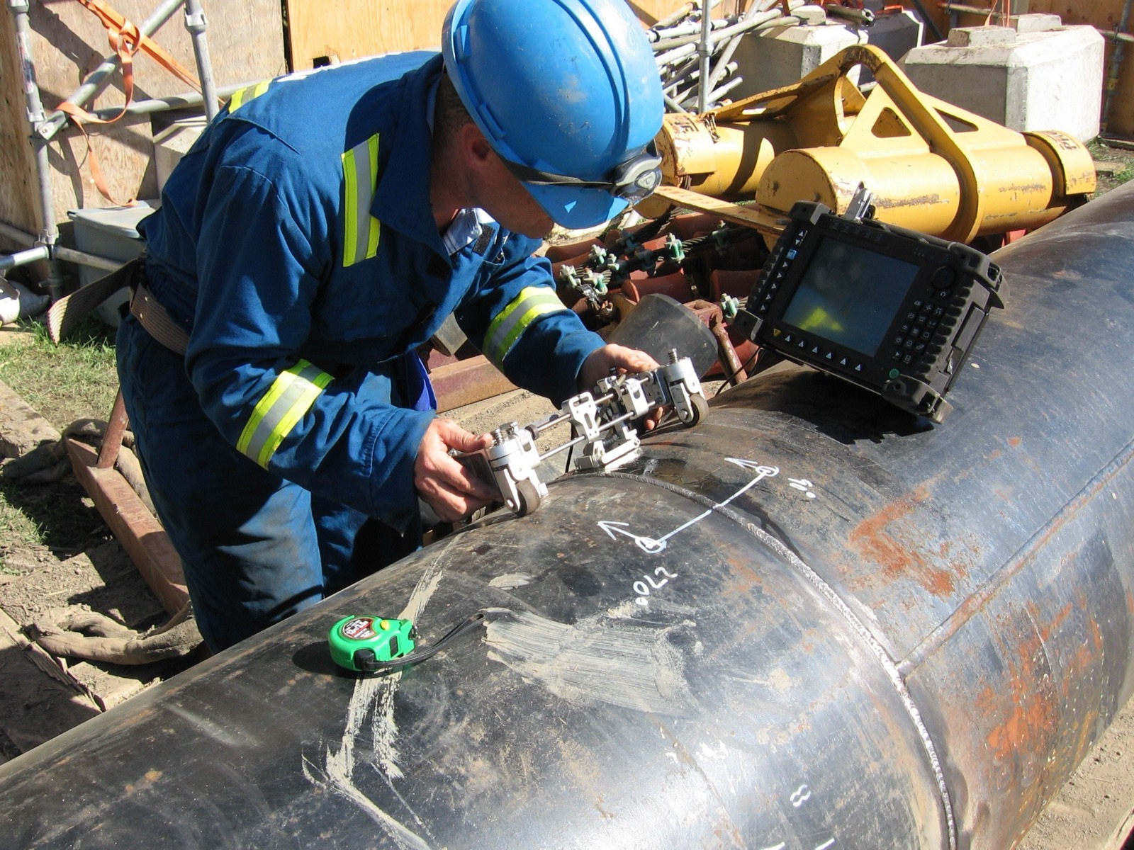 Inspector taking thickness readings on plant piping